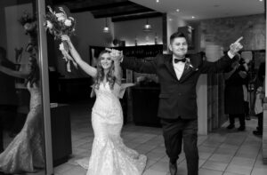 black and white photo of bride and groom entering wedding reception in Camden, New South Wales