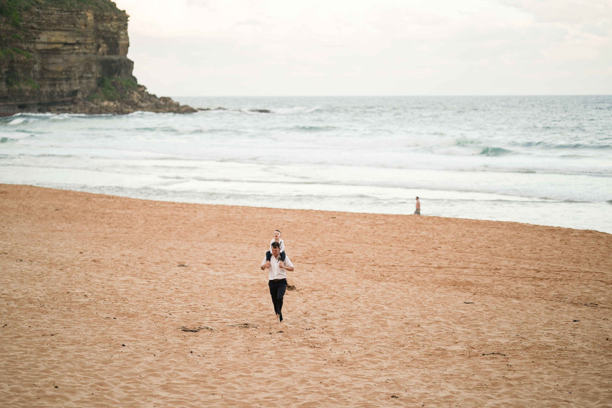 groom on beach at sunset after Sydney wedding