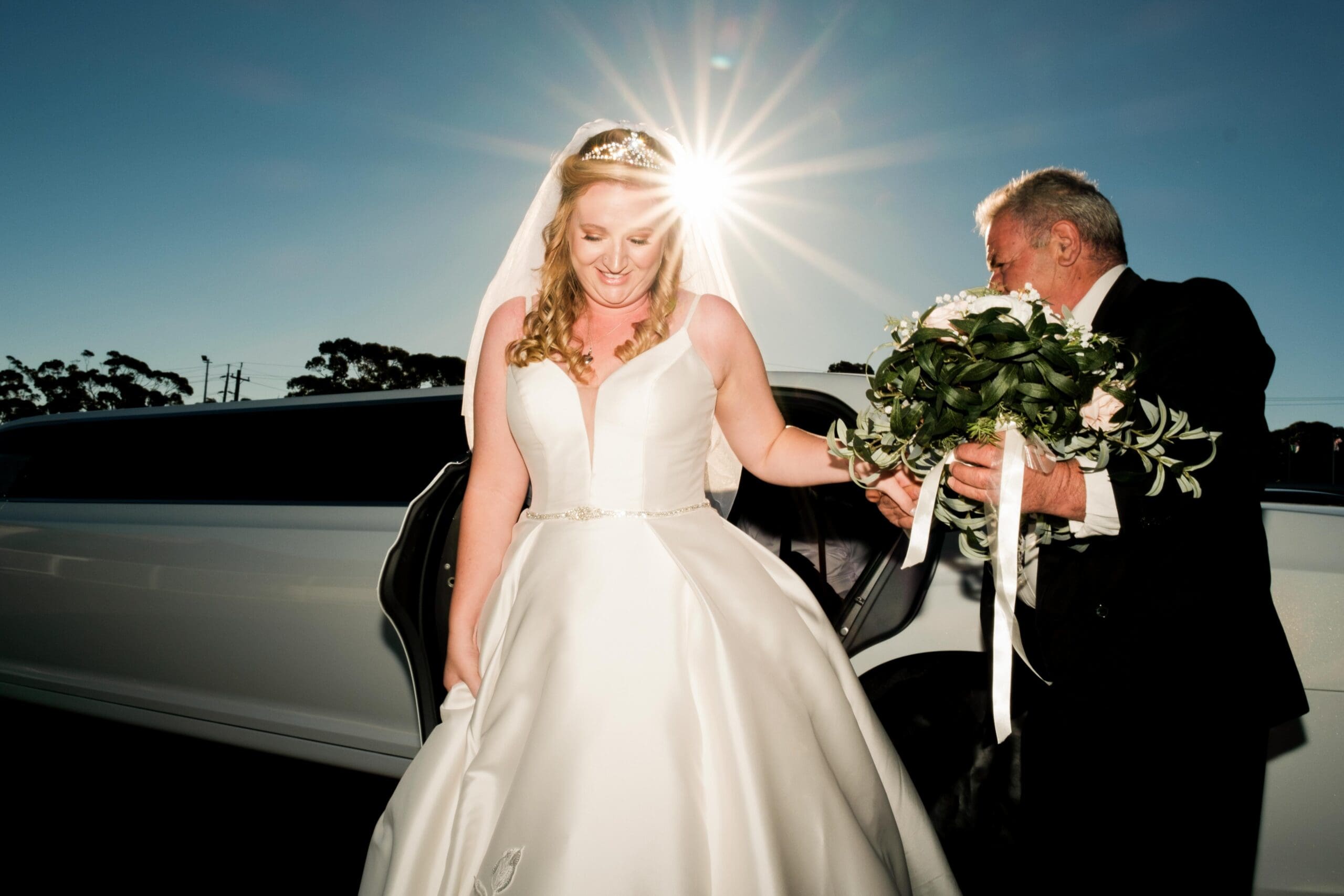 photo of bride getting out of car at wedding ceremony